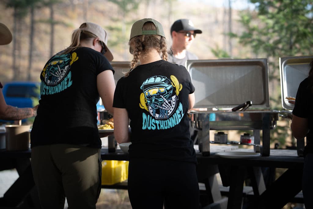 Volunteers in Dusthunniez shirts serving the chef-catered dinner.